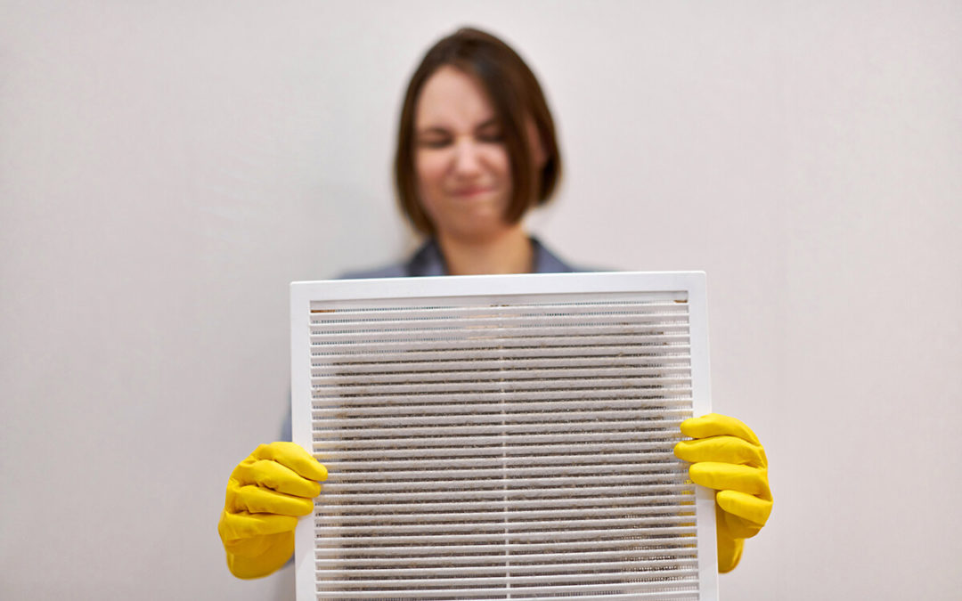 Woman holding dirty and dusty ventilation grille