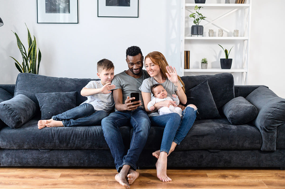 A diverse loving family of four using smartphone