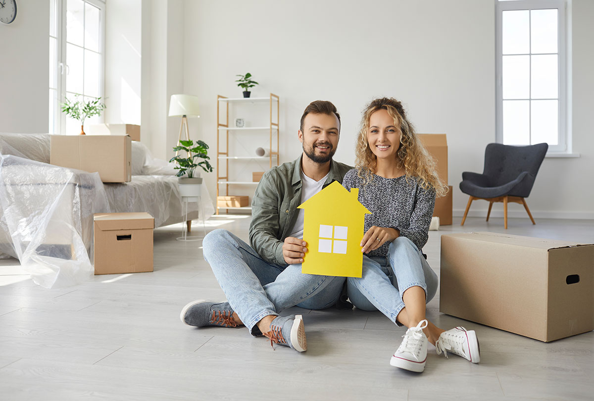 happy couple sitting among boxes on day of moving to their own new home happy couple sitting among boxes on day of moving to their own new home