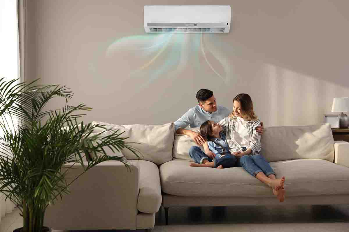 Happy family resting under air conditioner
